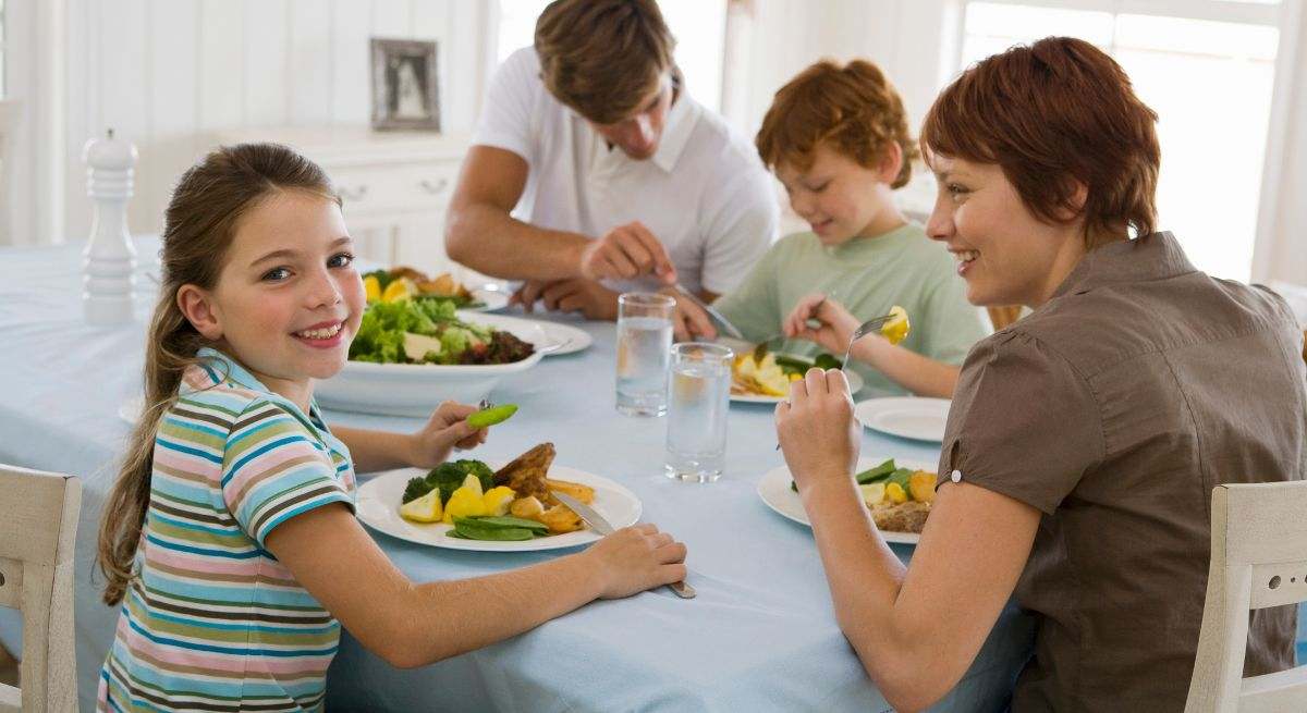 Familia cenando reunida en la mesa
