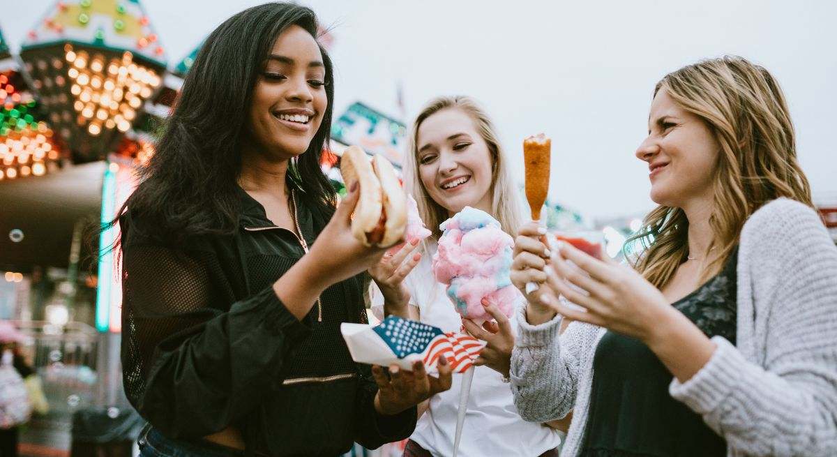 Varias jóvenes se compran comida en una feria