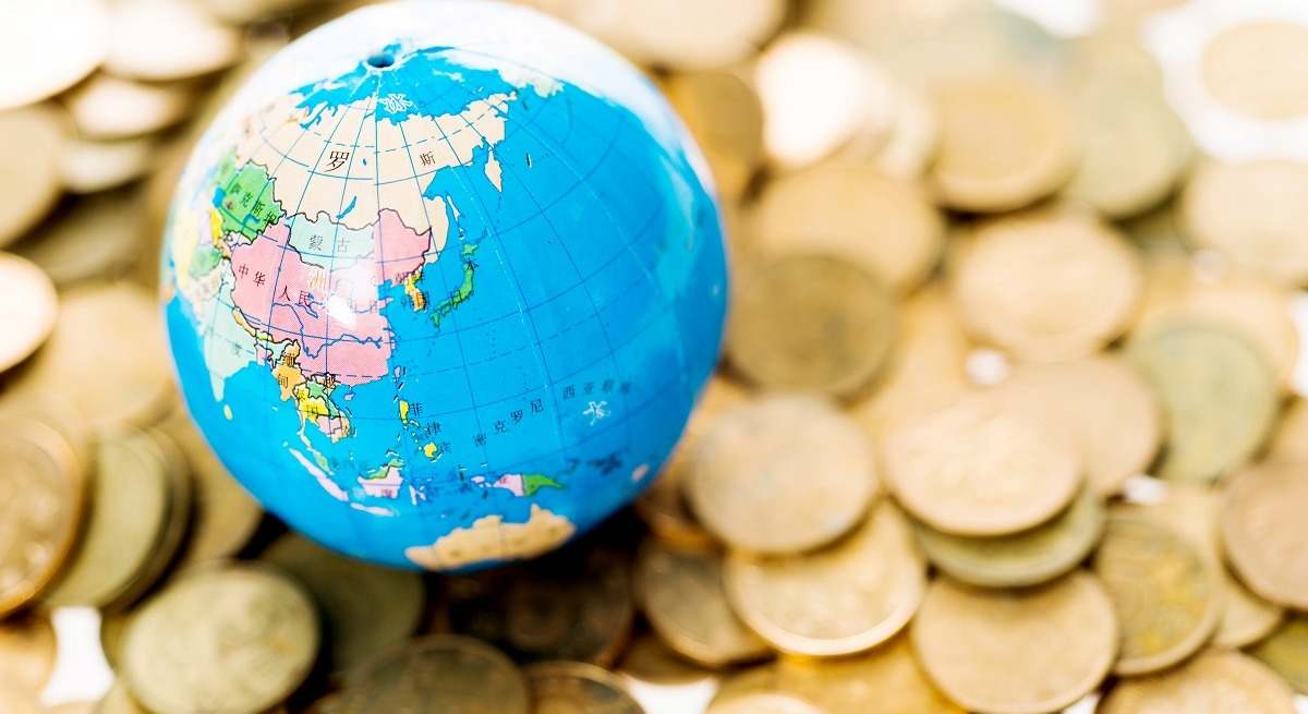 Una bola del mundo sobre monedas.
