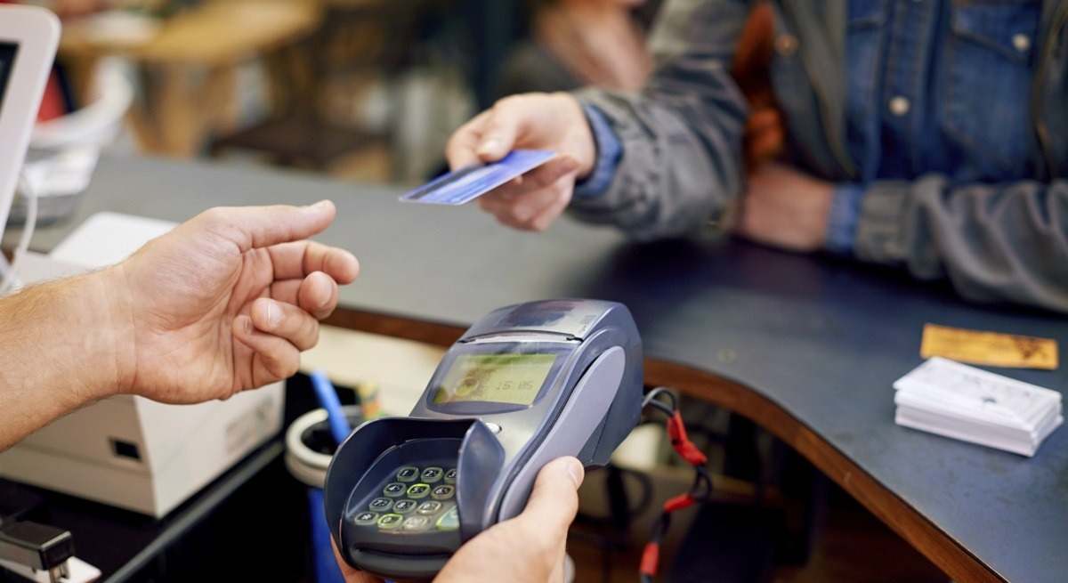 Una persona paga en un comercio con una tarjeta