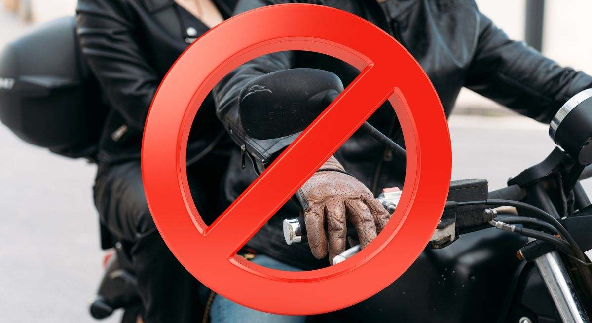 Montaje señal de prohibido con dos personas en una motocicleta de fondo