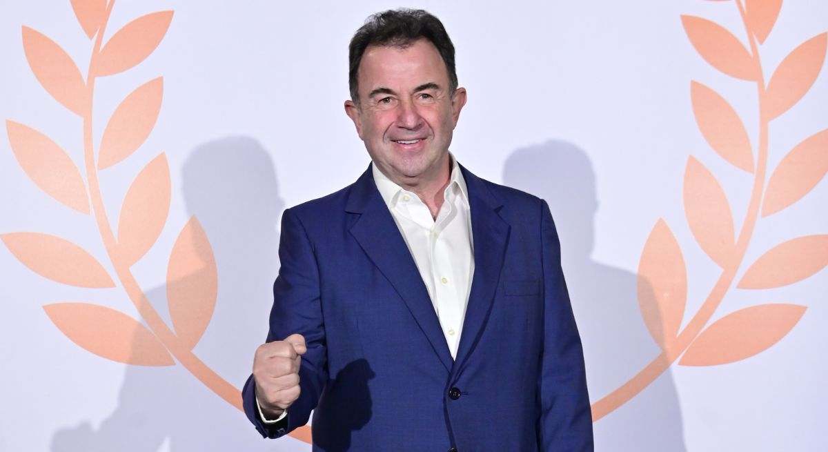 El chef posando en un photocall con un fondo de laureles