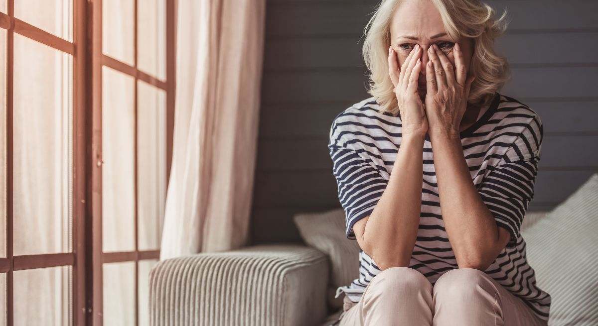 Una mujer viuda llora en su casa.