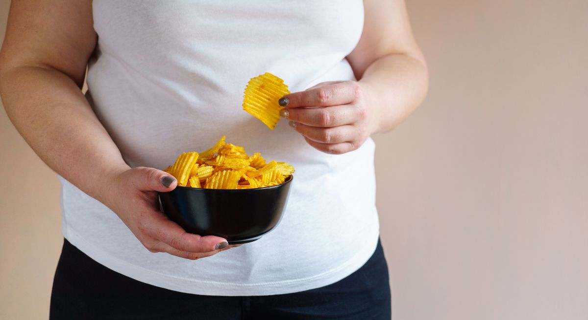 Una mujer come patatas fritas en su hogar 