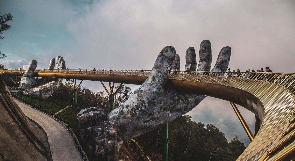 manos saliendo de la tierra y sujetando un puente de oro