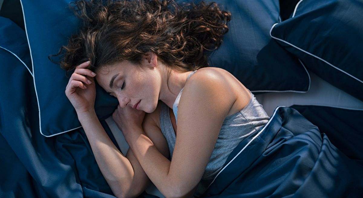 Una persona descansa profundamente en su cama