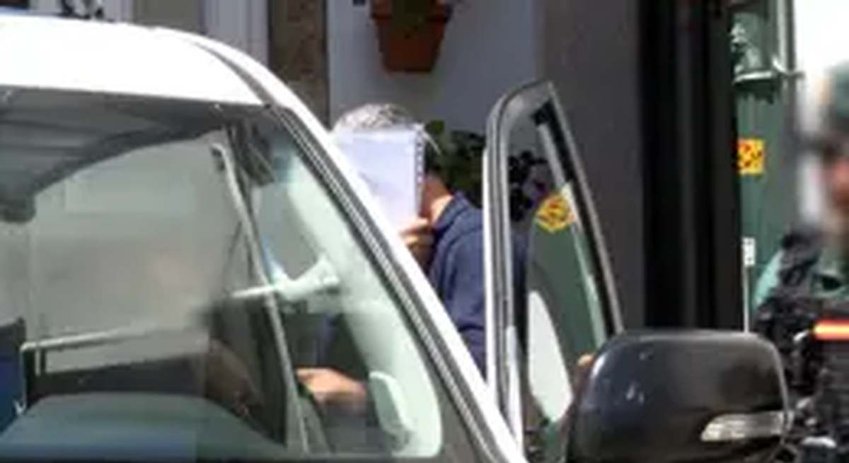El empresario investigado en Santaigo en una operación de la UCO contra los delitos fiscales es introducido en una patrulla de la Guardia Civil.