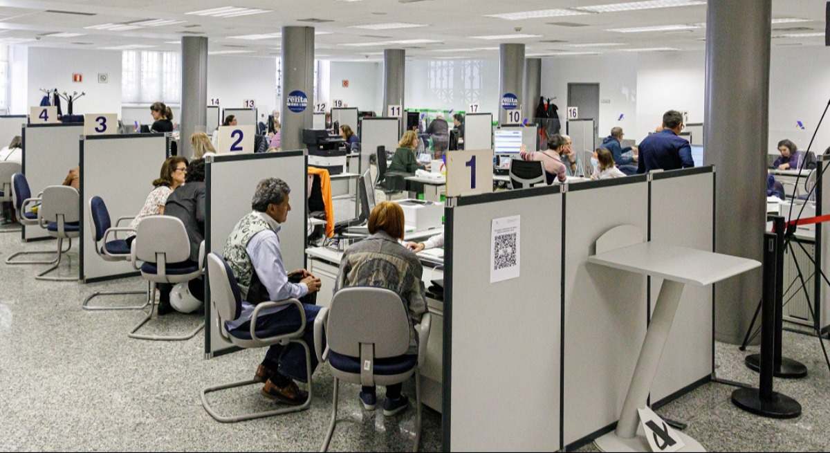 Vista de una oficina con funcionarios atendiendo a ciudadanos.