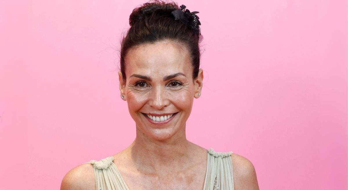 Inés Sastre con vestido blanco de tirantes y un fondo rosa