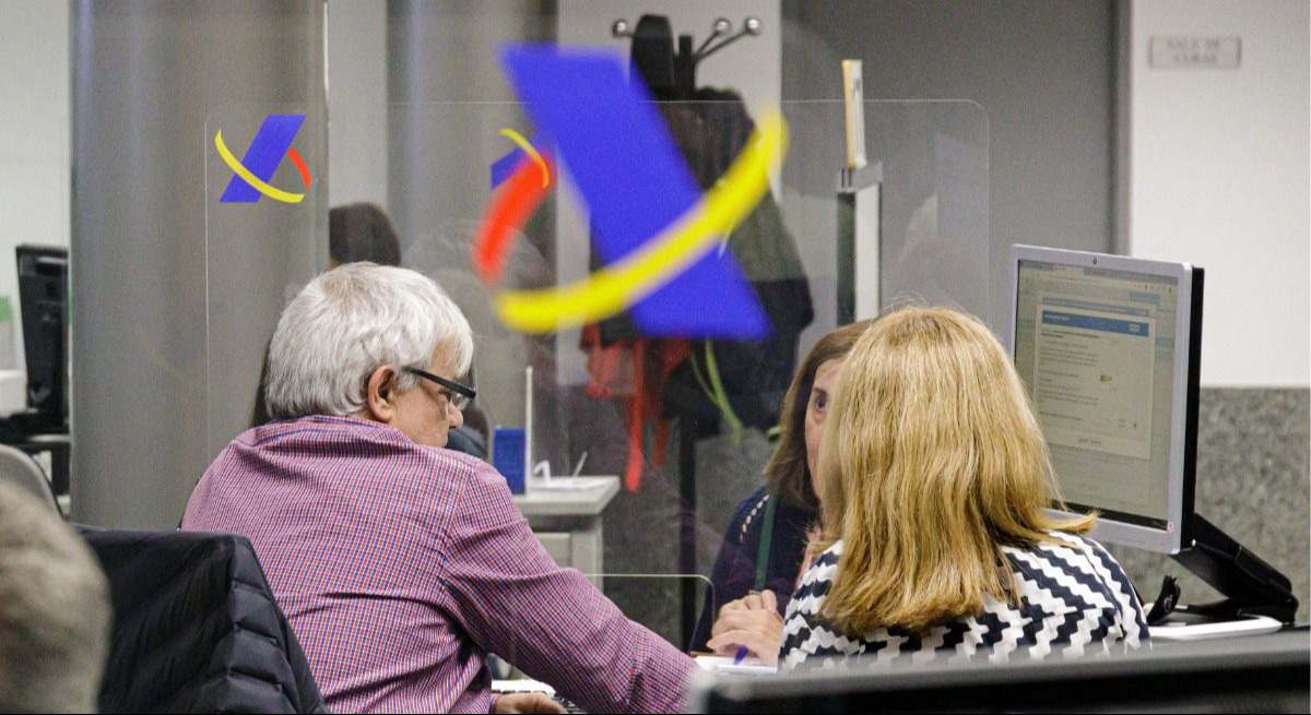 Dos personas son atendidas en una oficina de la Agencia Tributaria. / Foto: EP