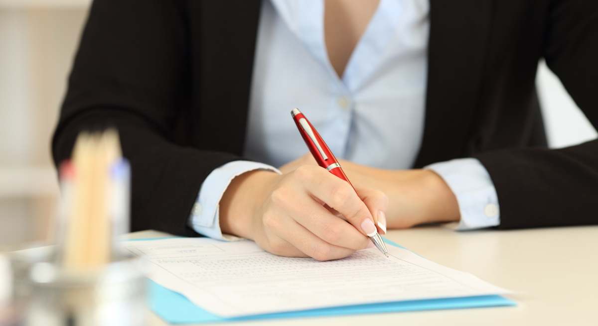 Mujer firma un contrato