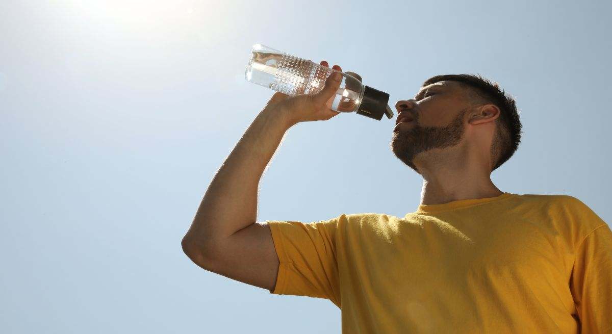hombre-bebe-agua-calor-canva.jpg