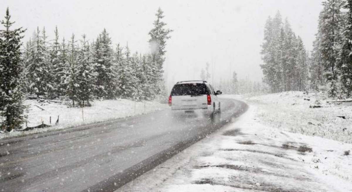 coche en circulación sobre una carretera nevada