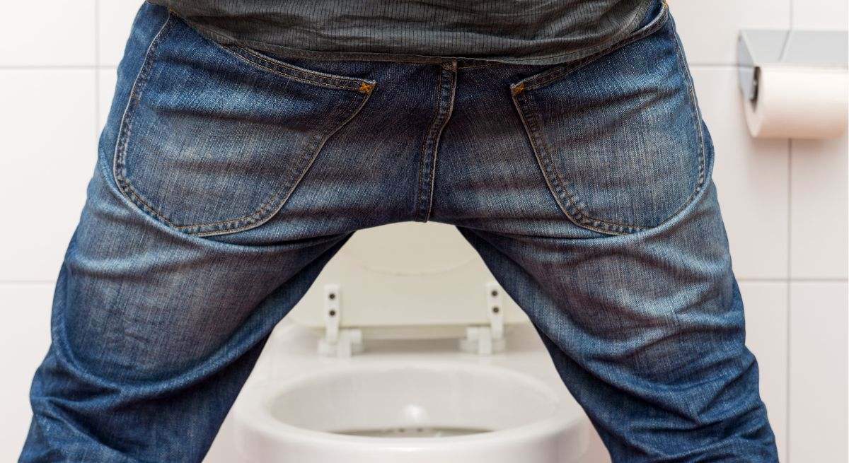 Un hombre orina en su baño