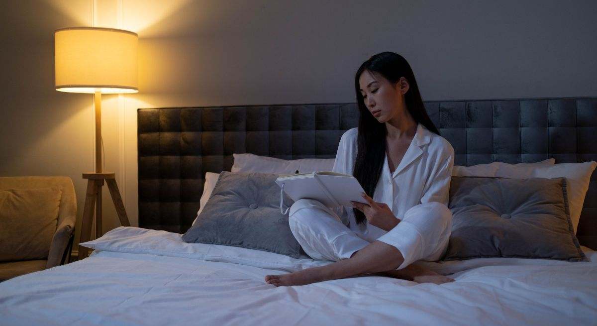 Una persona lee en su cama antes de irse a dormir