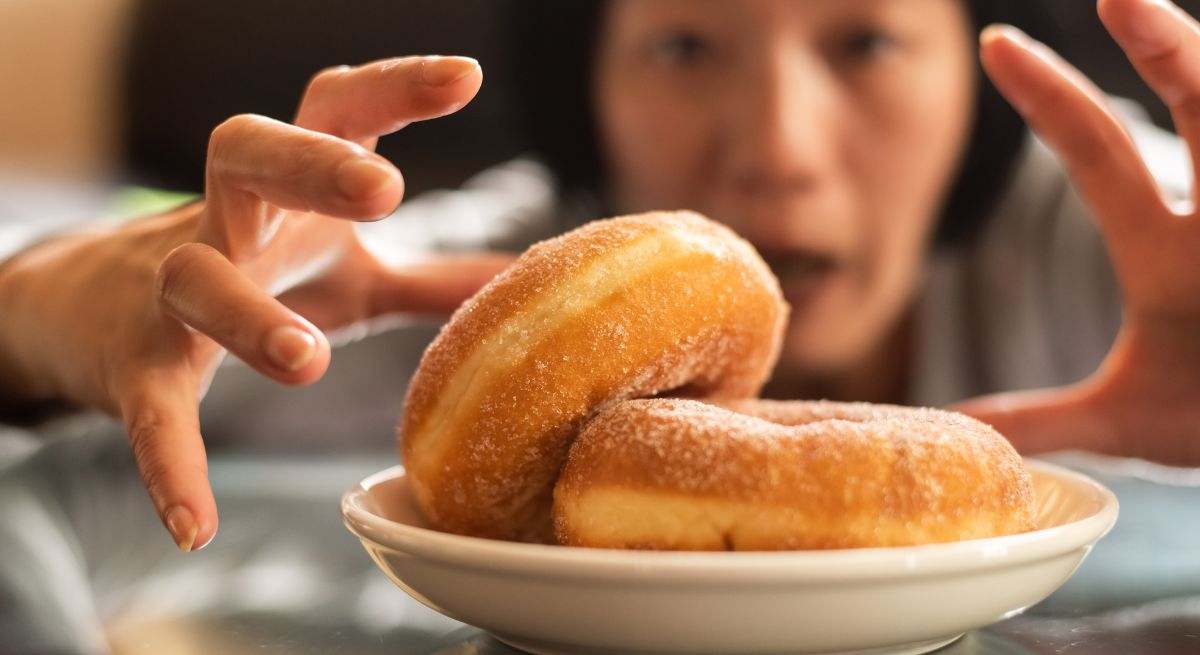Una mujer está a punto de comerse un dulce