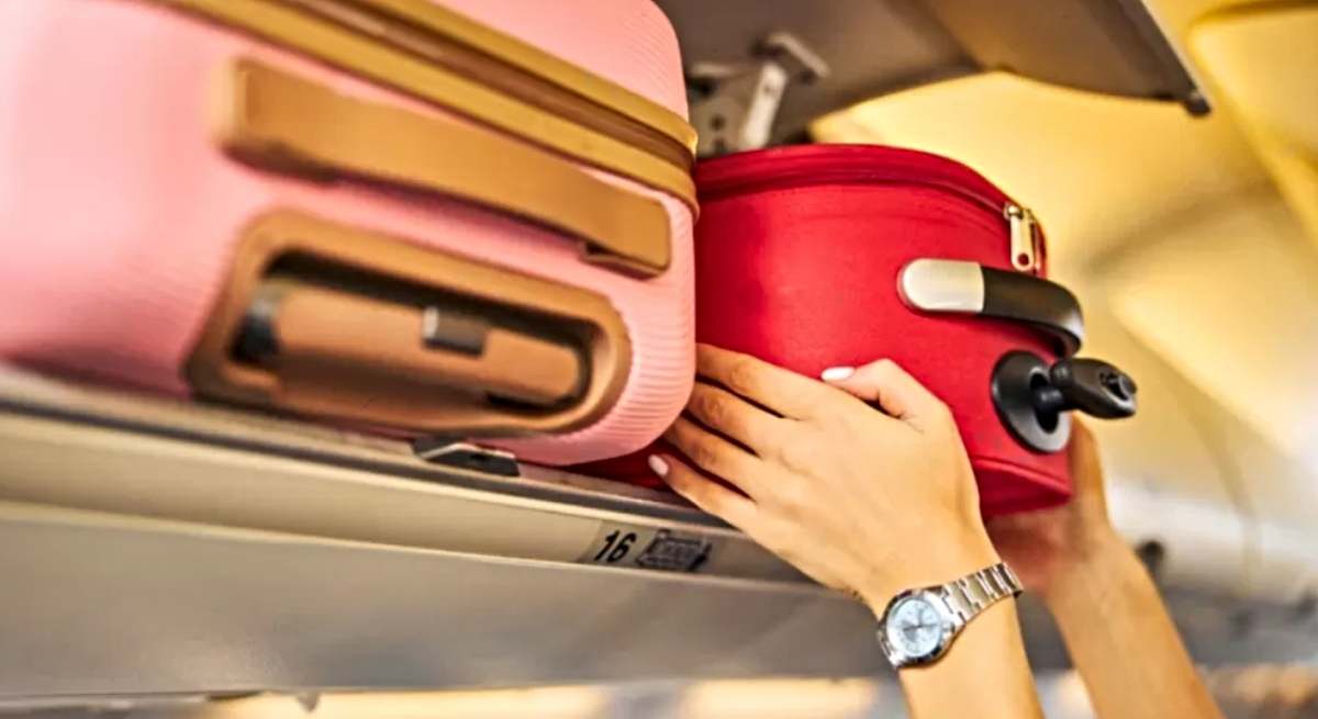 Una persona coloca su equipaje de mano en un avión