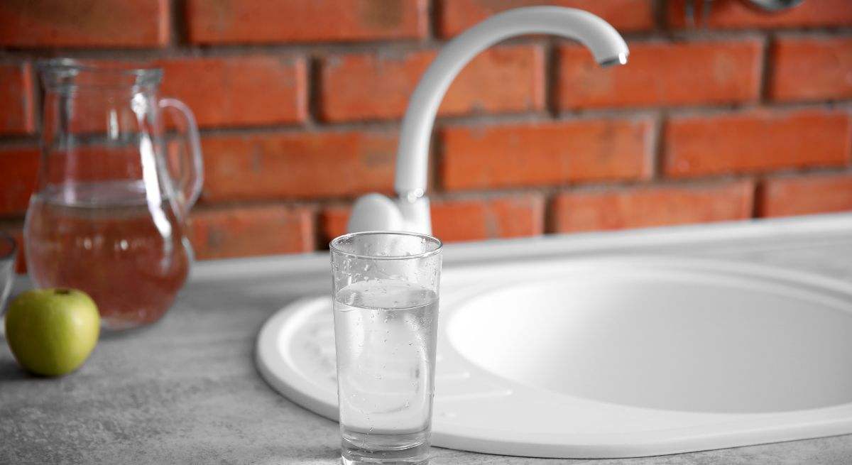 Vaso de agua al lado de un fregadero de la cocina