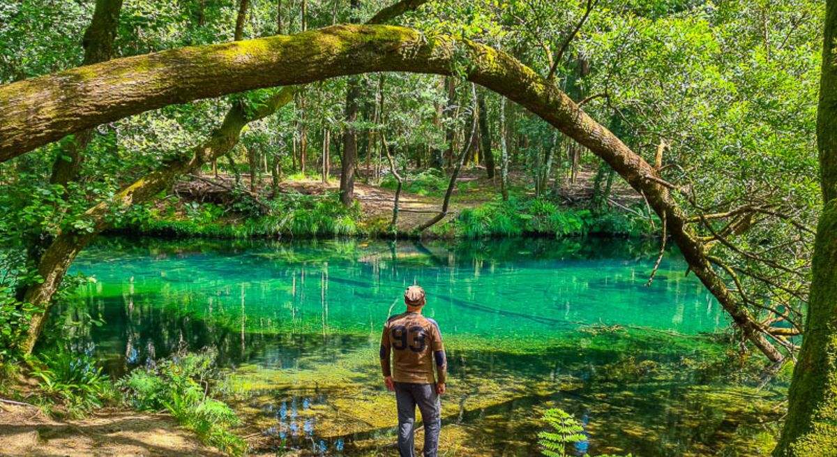 Hombre mirando una laguna turquesa