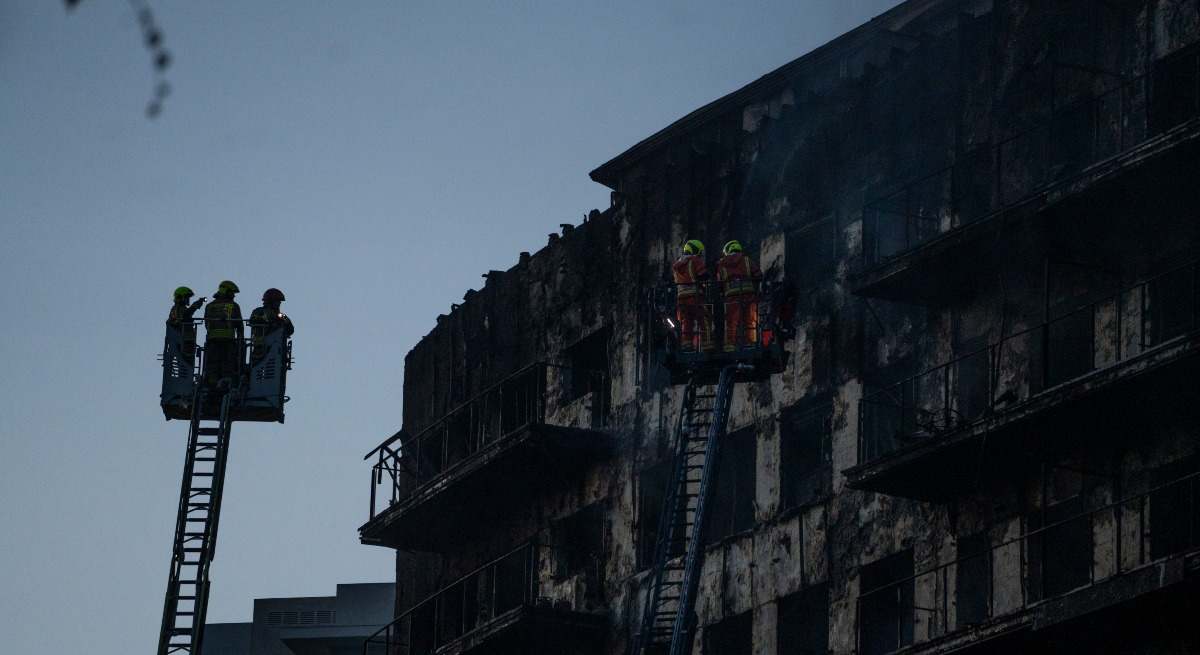 Los bomberos trabajan en el incendio de ayer, 22 de febrero, en el barrio de Campanar,