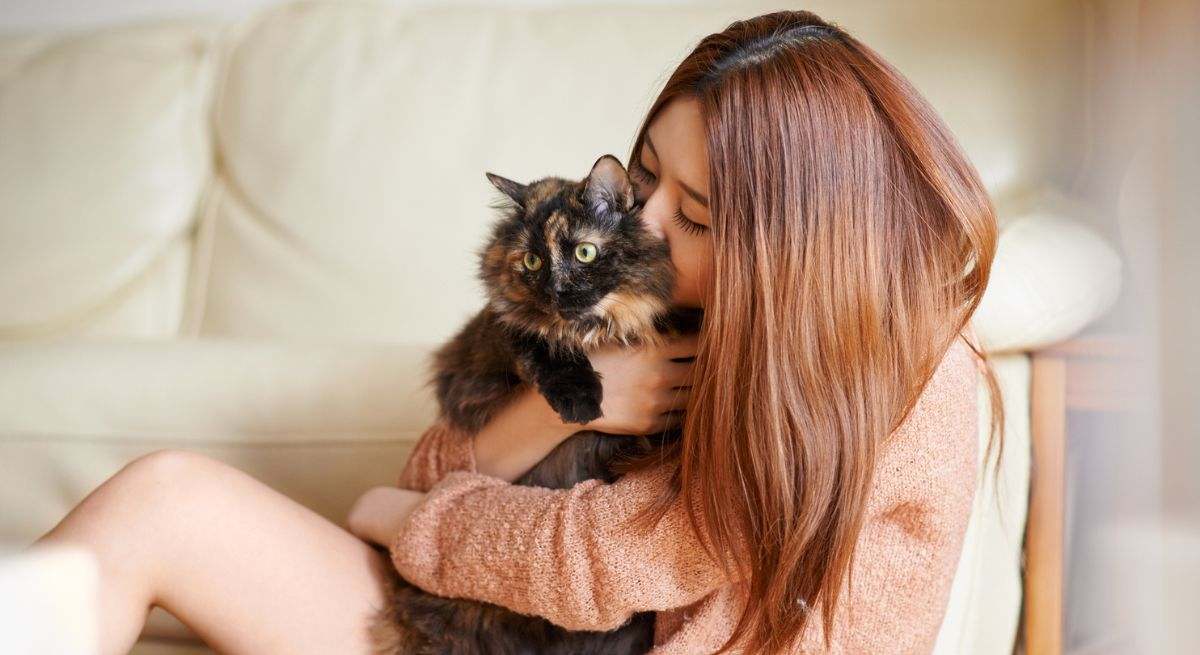 Una chica abraza y besa a su gato. / Foto: iStock