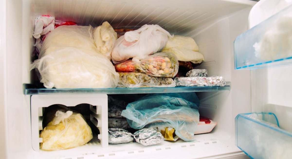 Congelador abierto con alimentos en su interior