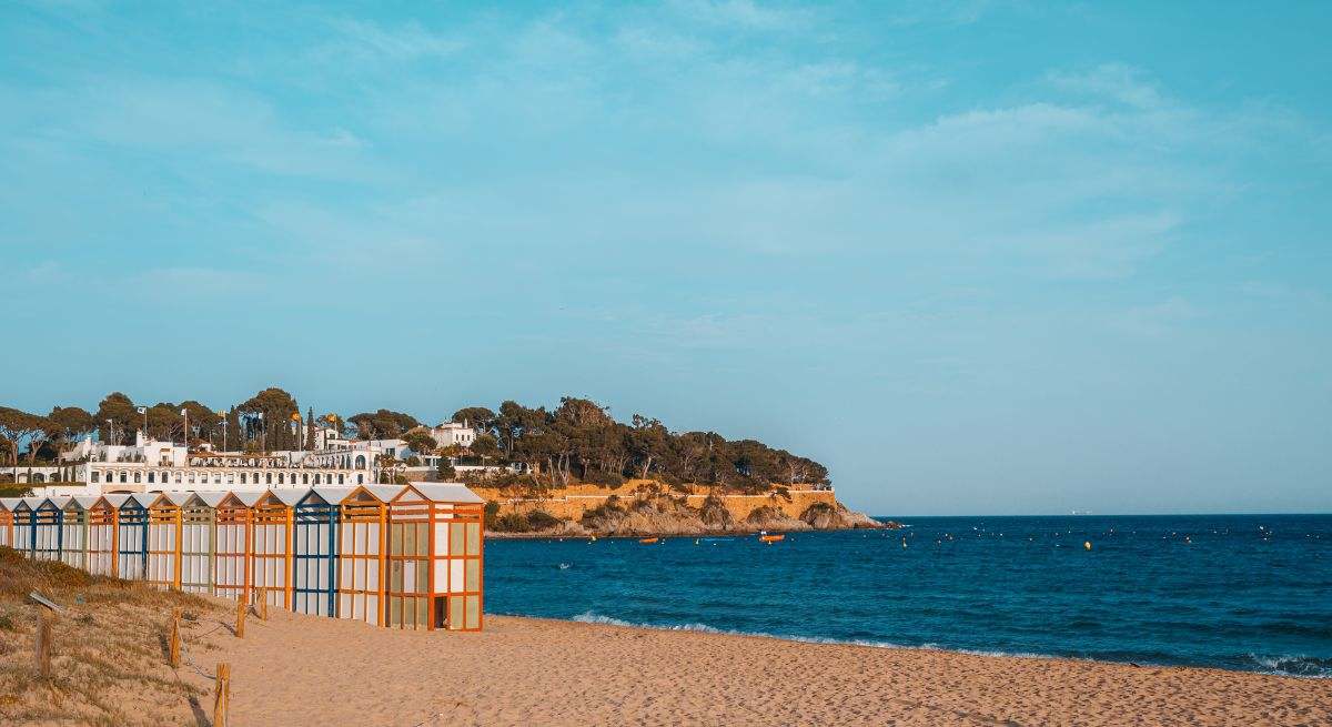 Una de las playas más impresionantes de Barcelona con arena dorada y aguas de un fuerte azul. En medio del arenal se encuentran los coloridos baños portátiles de esta playa