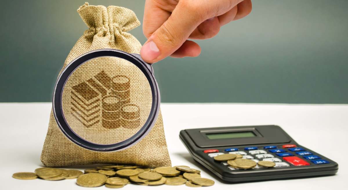 Una lupa sobre una bolsa de dinero
