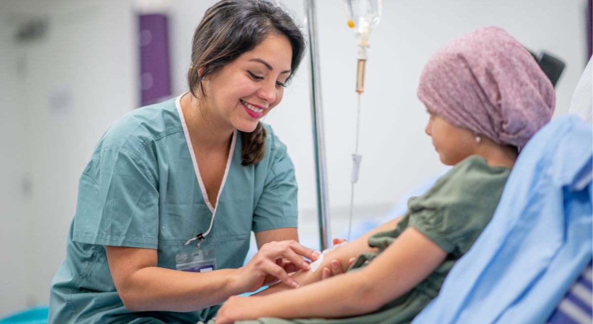 Una niña con cáncer habla con una enfermera