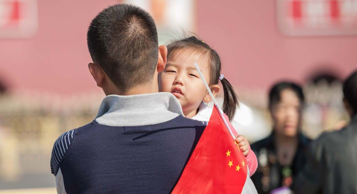 Un padre con su hija y una bandera de China. Foto: iStock