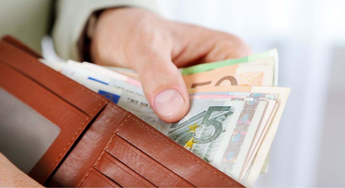 Persona sacando dinero de la cartera