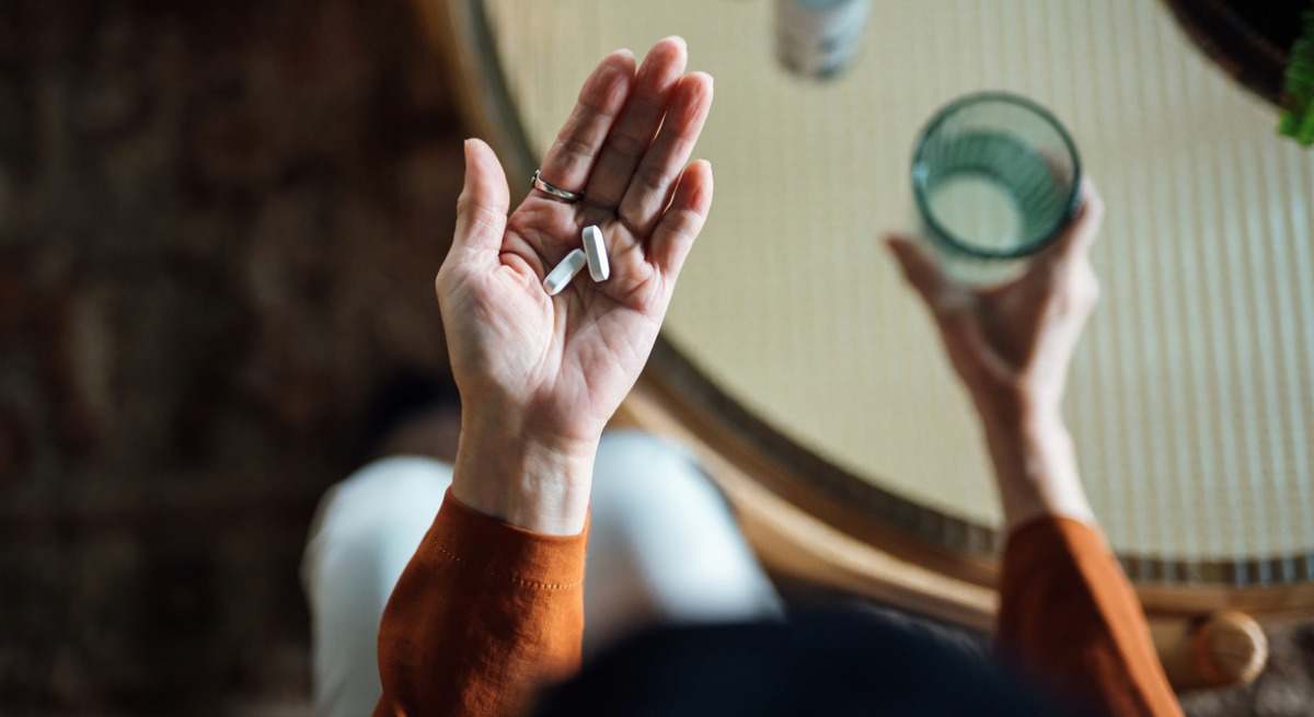 Mano de mujer a punto de tomar pastillas 