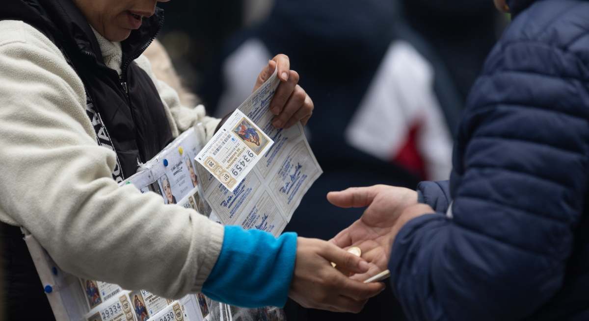 Una persona compra en la calle un décimo de Lotería.