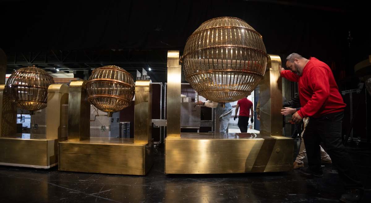 Un operario mueve los bombos de la Lotería de Navidad en Palacio Real.