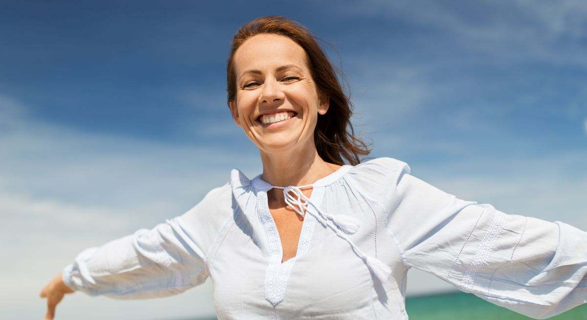 Mujer feliz con el cielo de fondo