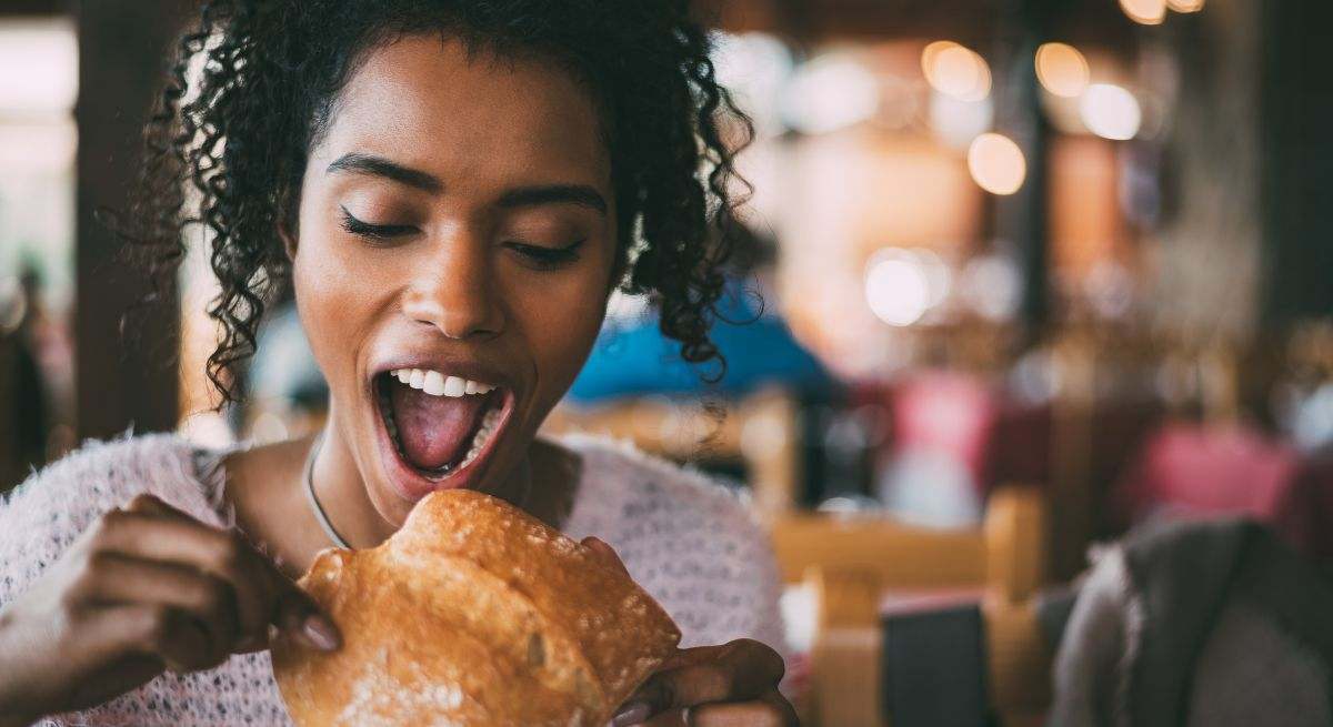 Una mujer joven toma pan para desayunar