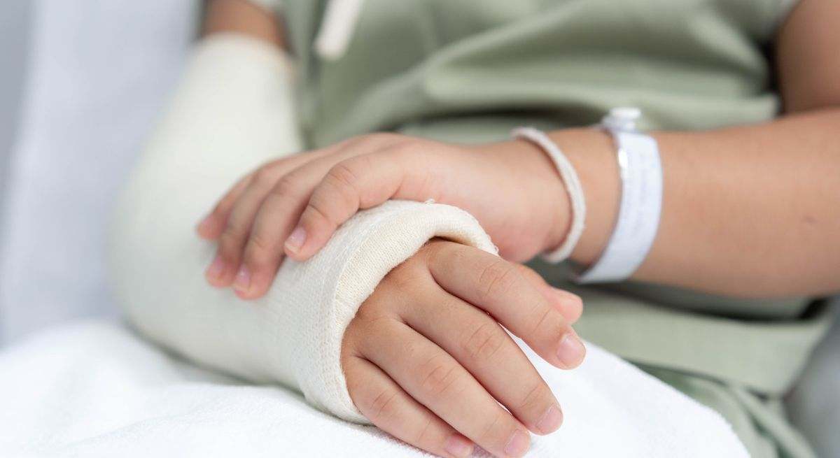 Una joven con un brazo escayolado
