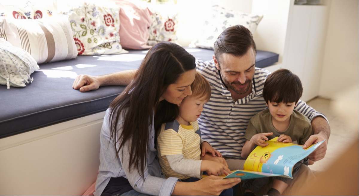 Familia leyendo un libro.