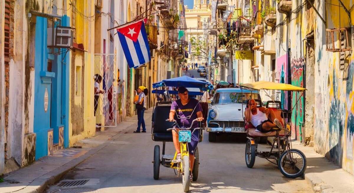 bici-taxis-y-auto-antiguo-en-una-calle-de-la-habana-traslados-en-cuba.jpg