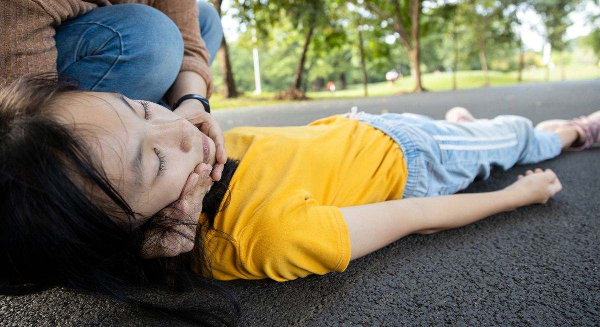 Una persona se cae en medio de la calle y una mujer la socorre de inmediato