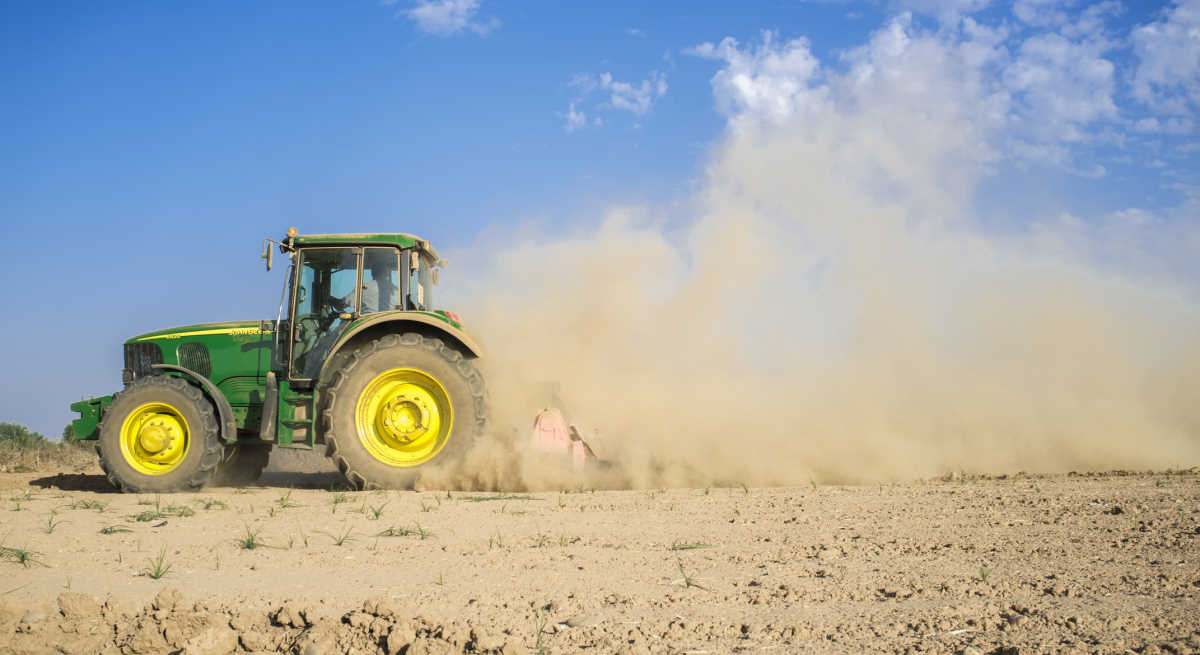 Un tractor por el campo levantando polvo
