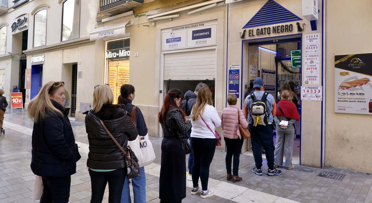 Personas esperando en una cola para comprar Lotería de Navidad.