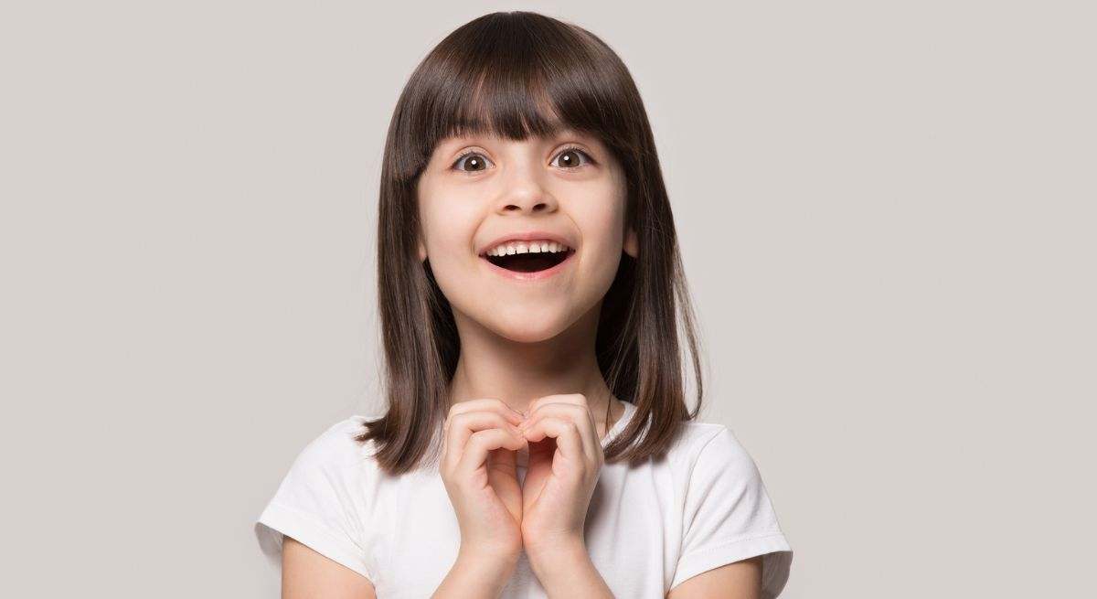 Niña pequeña haciendo un corazón con las manos
