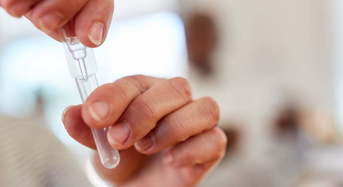Manos con un test de saliva