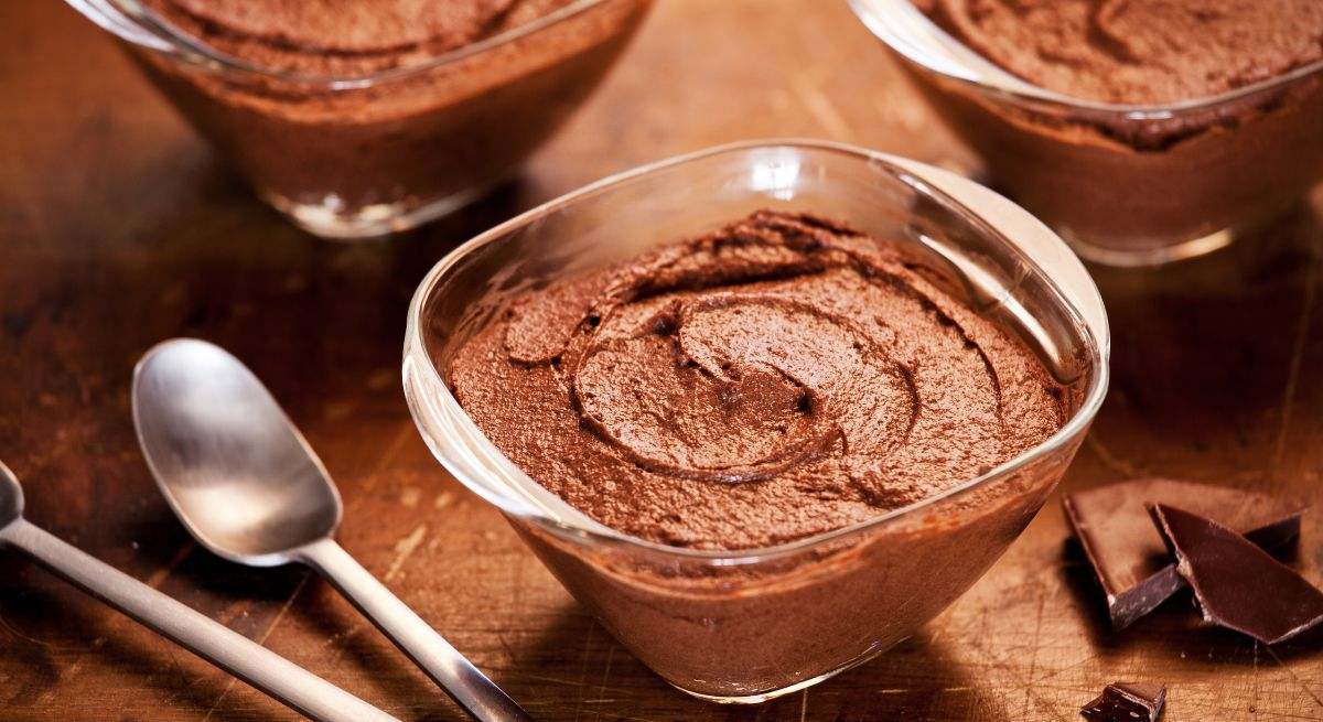 Varios cuencos de mousse de chocolate y dos cucharas