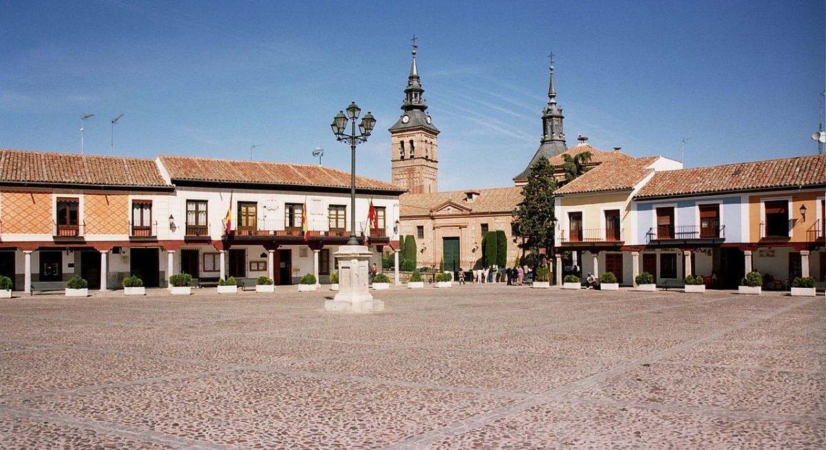 La plaza del pueblo con casas a los lados del mismo color blanco y tejados de tejas