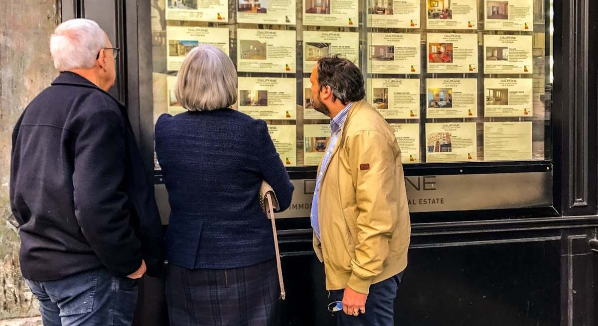Tres personas mirando anuncios de pisos. Foto: iStock