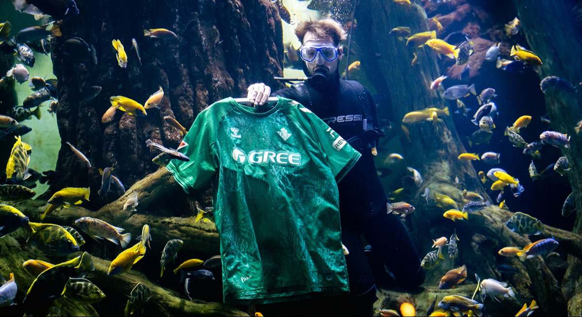 Presentación de la camiseta del Betis elaborada con alga asiática invasora bajo el agua.