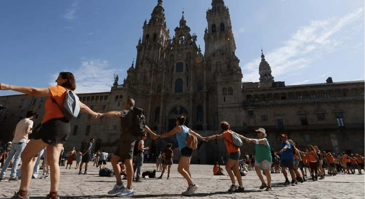 Peregrinos celebran el en Obradoiro su llegada a Compostela.