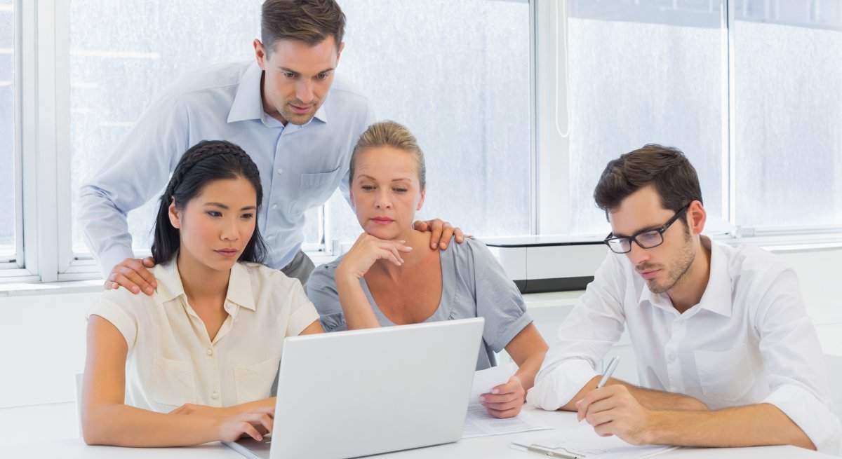 casual-business-team-working-together-at-desk-using-laptop.jpg